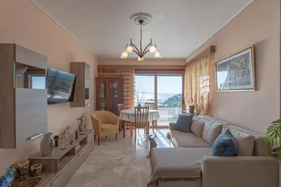 a living room with a couch and a table at Feliz Apt- Breathtaking Seaview and Sunset by ΜΡS in Anavissos