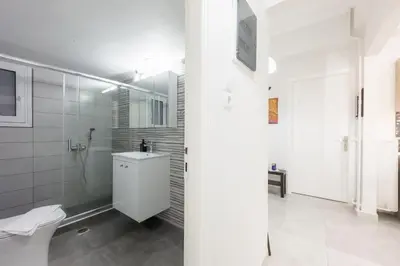 a white bathroom with a sink and a toilet at New Spacious & Stylist Apt in Piraeus