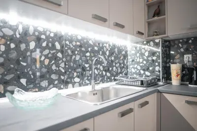 a kitchen with a sink and a stone wall at New Spacious & Stylist Apt in Piraeus