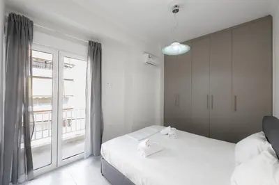 a bedroom with two beds and a large window at New Spacious & Stylist Apt in Piraeus