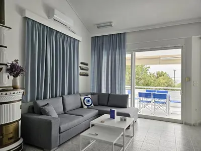 a living room with a couch and a table at Lagonisi Beach House in Lagonissi