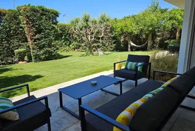 a patio with a couch and a table and chairs at Lagonisi Beach House in Lagonissi