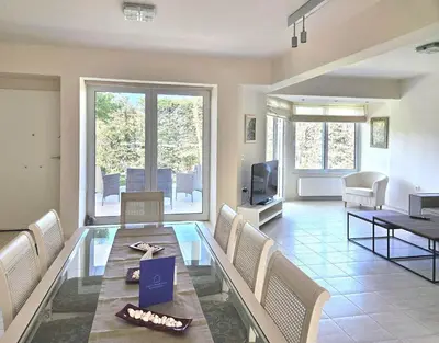 a living room with a glass table and chairs at Lagonisi Beach House in Lagonissi