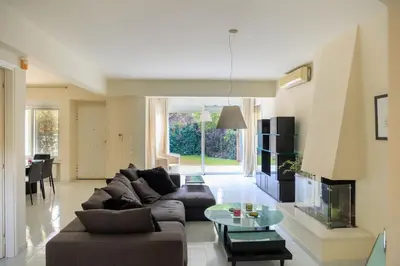 a living room with a couch and a table at Lagonisi Beach House in Lagonissi