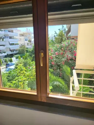 a window with a view of a garden of flowers at Luxe Apartment in Central Glyfada in Athens