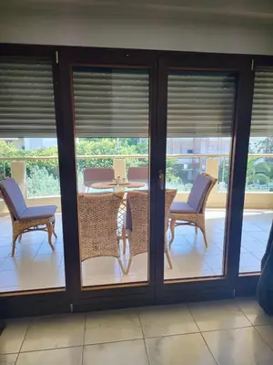 a room with sliding glass doors with a table and chairs at Luxe Apartment in Central Glyfada in Athens