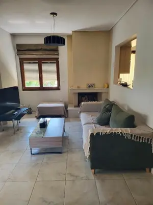a living room with a couch and a table at Luxe Apartment in Central Glyfada in Athens