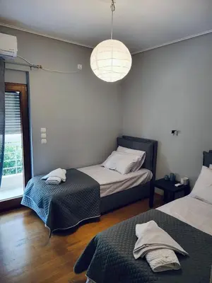 a bedroom with two beds and a large window at Luxe Apartment in Central Glyfada in Athens