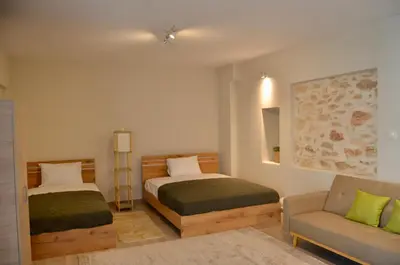 a bedroom with two beds and a chair and a couch at Harihara Guesthouse near Airport in Paianía