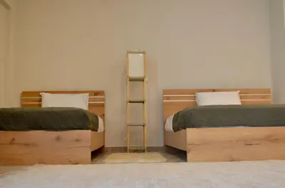 a room with two beds and a ladder between them at Harihara Guesthouse near Airport in Paianía