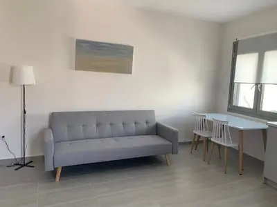 a living room with a couch and a table at Harihara Guesthouse near Airport in Paianía