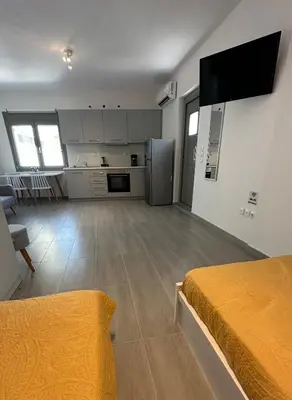 a large room with a kitchen and a bed in it at Harihara Guesthouse near Airport in Paianía