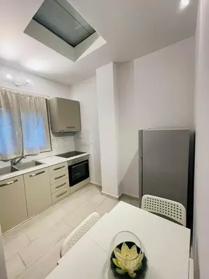 a kitchen with a white table and a refrigerator at Harihara Guesthouse near Airport in Paianía
