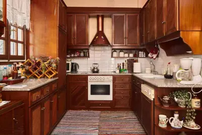 a kitchen with wooden cabinets and a stove top oven at Spacious central apartment wh free parking spaces in Athens