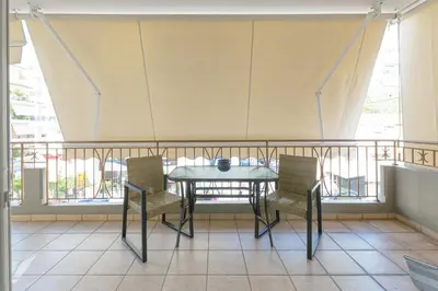 a table and two chairs on a balcony at Family Sunny 2 bedroom near center 50m busstop,300m busstop Acropolis in Athens
