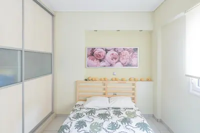 a bedroom with a bed and a painting on the wall at Family Sunny 2 bedroom near center 50m busstop,300m busstop Acropolis in Athens