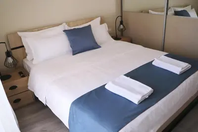 a large white bed with blue and white pillows at Dafni City Apartment 5 in Athens