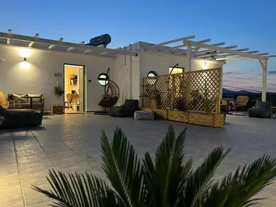 a patio of a house at night with at Airport Luxury Stay in Artemida
