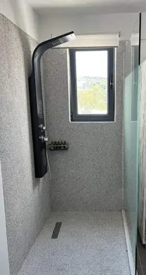 a shower with a window and a television in a bathroom at Airport Luxury Stay in Artemida