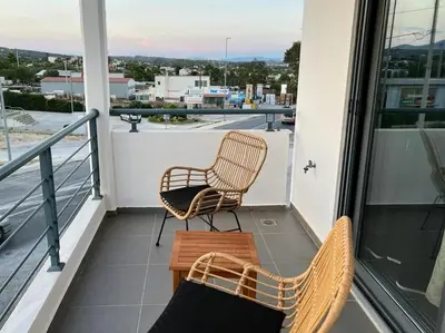 a balcony with two chairs and a table at Airport Luxury Stay in Artemida