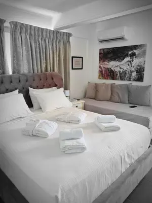 two beds in a room with white towels on them at Airport Luxury Stay in Artemida