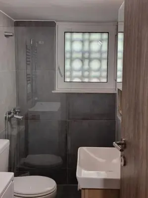 a bathroom with a toilet and a sink and a window at Harmony in everything in Athens