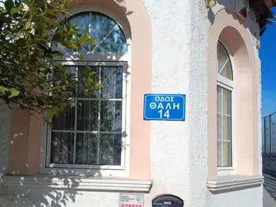 a blue street sign on the side of a building at Metro Paĺlini Rooms to Rent 20 min to Syntagma 15 minutes to Airport 24 hours train Bus and 200 meter aŵay in Pallíni