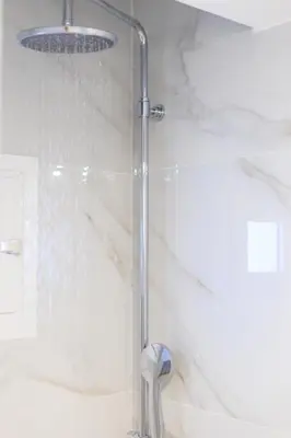 a shower with a glass door in a bathroom at Aiolos new Smyrni view loft suite in Athens