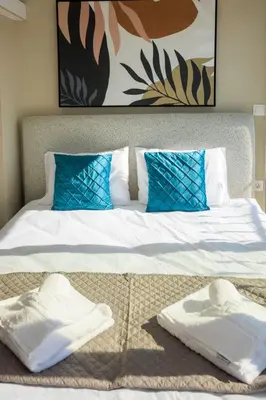 a bed with two white towels sitting on it at Aiolos new Smyrni view loft suite in Athens