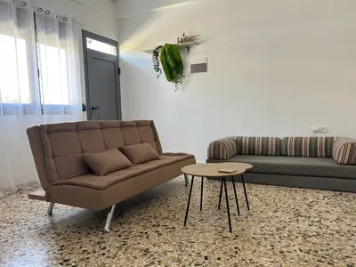 a living room with a couch and a table at Paola’s Apartment Near Athens Airport in Spáta