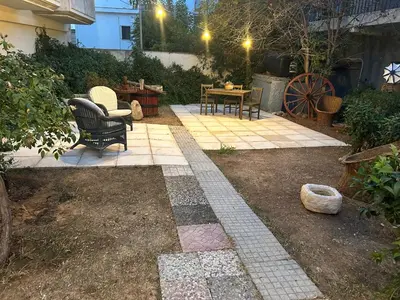 a patio with chairs and a table in a yard at Paola’s Apartment Near Athens Airport in Spáta