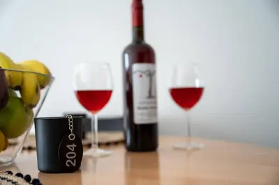 a bottle of wine and two glasses of red wine at Anesis Airport rooms 204 in Koropíon