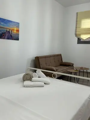 a living room with a couch and towels on the floor at Paola’s apartments near Athens Airport in Spáta