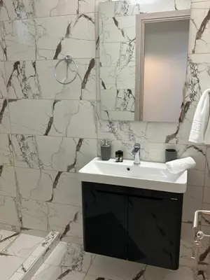 a white bathroom with a sink and a mirror at Paola’s apartments near Athens Airport in Spáta