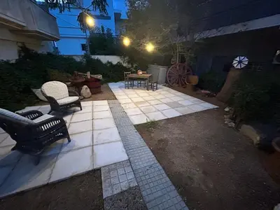 a patio with two chairs and a table at night at Paola’s apartments near Athens Airport in Spáta