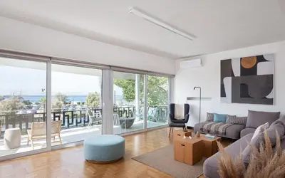 a living room with a couch and a large window at Glyfada Unique Residence in Athens