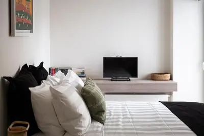 a bedroom with a bed with pillows and a television at Glyfada Unique Residence in Athens