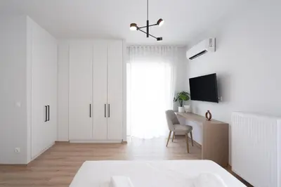 a white bedroom with a bed and a desk at Luxury 4 Bedrooms Apartment Near Flisvos Marina in Piraeus