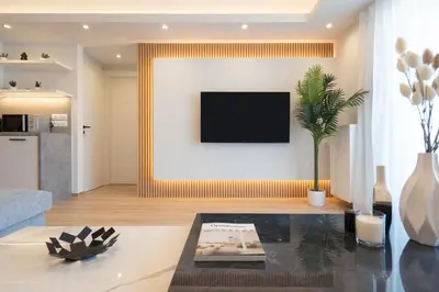 a living room with a tv on a wall at Luxury 4 Bedrooms Apartment Near Flisvos Marina in Piraeus