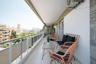 a balcony with wicker chairs and a table at Luxury 4 Bedrooms Apartment Near Flisvos Marina in Piraeus