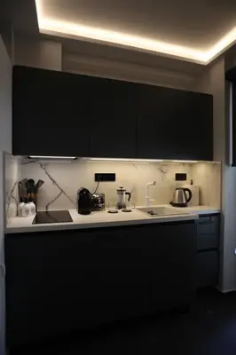 a kitchen with black cabinets and a white counter top at Only2Suites in Athens