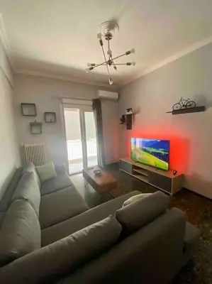 a living room with a couch and a flat screen tv at Lovely flat Korydallos in Piraeus