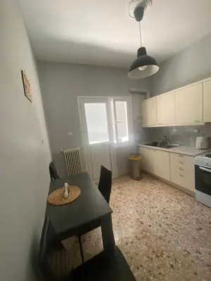 a kitchen with a table and chairs in a room at Lovely flat Korydallos in Piraeus