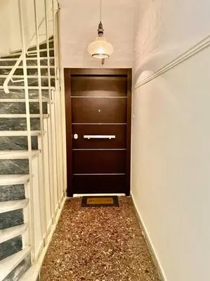 a hallway with a brown door and a staircase at Lovely flat Korydallos in Piraeus
