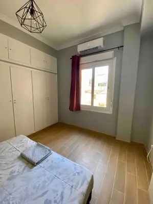 an empty room with a bed and a window at Cozy flat Korydallos in Piraeus