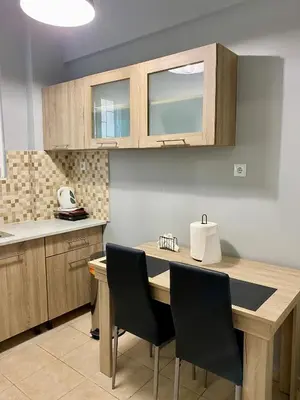 a kitchen with a wooden table and chairs at Cozy flat Korydallos in Piraeus