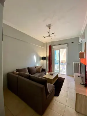 a living room with a couch and a table at Cozy flat Korydallos in Piraeus