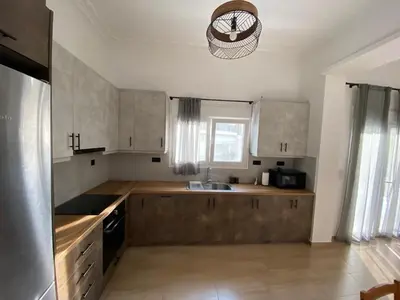 a kitchen with wooden cabinets and a sink and a window at Azure House in Athens