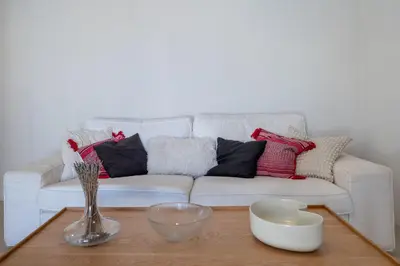 a living room with a white couch with pillows at Astrid in Athens