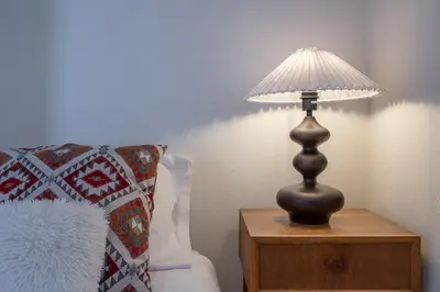 a lamp on a night stand next to a bed at Astrid in Athens